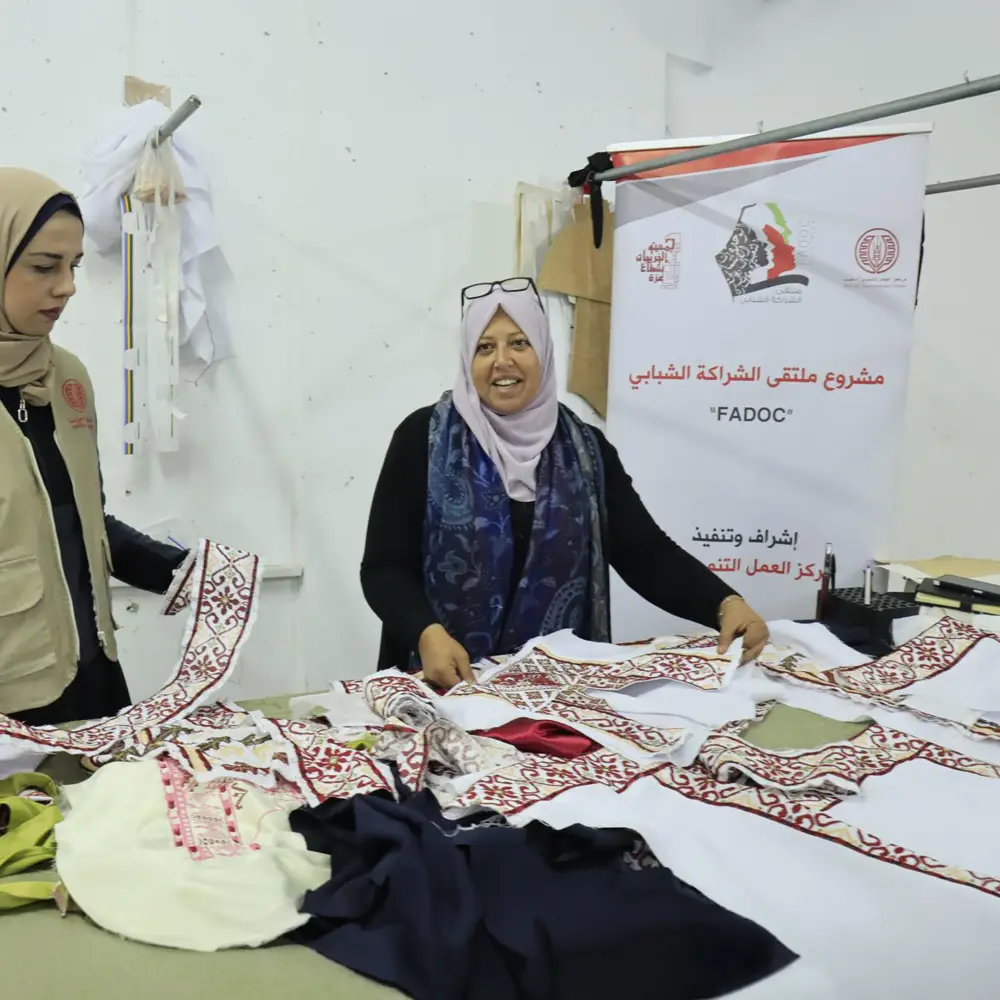 Femmes réunies autour d’une table couverte de tissus