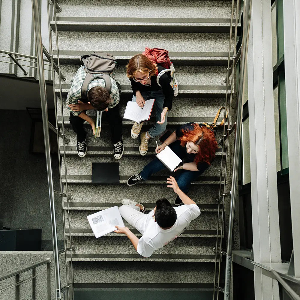 Groupe de jeunes dans un escalier, entourés de feuilles de papier
